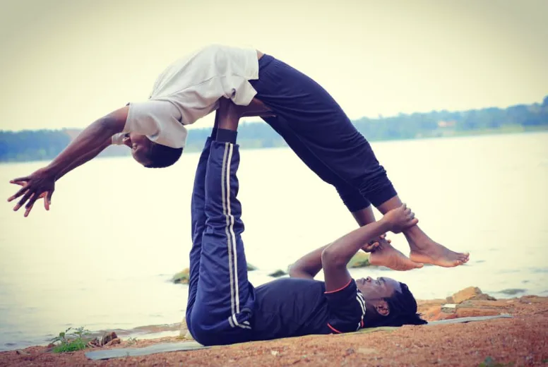 Partner duo yoga session by the lakeside in Entebbe